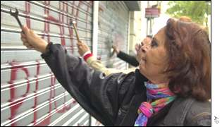 Angry Argentines hammer the shutters at a bank