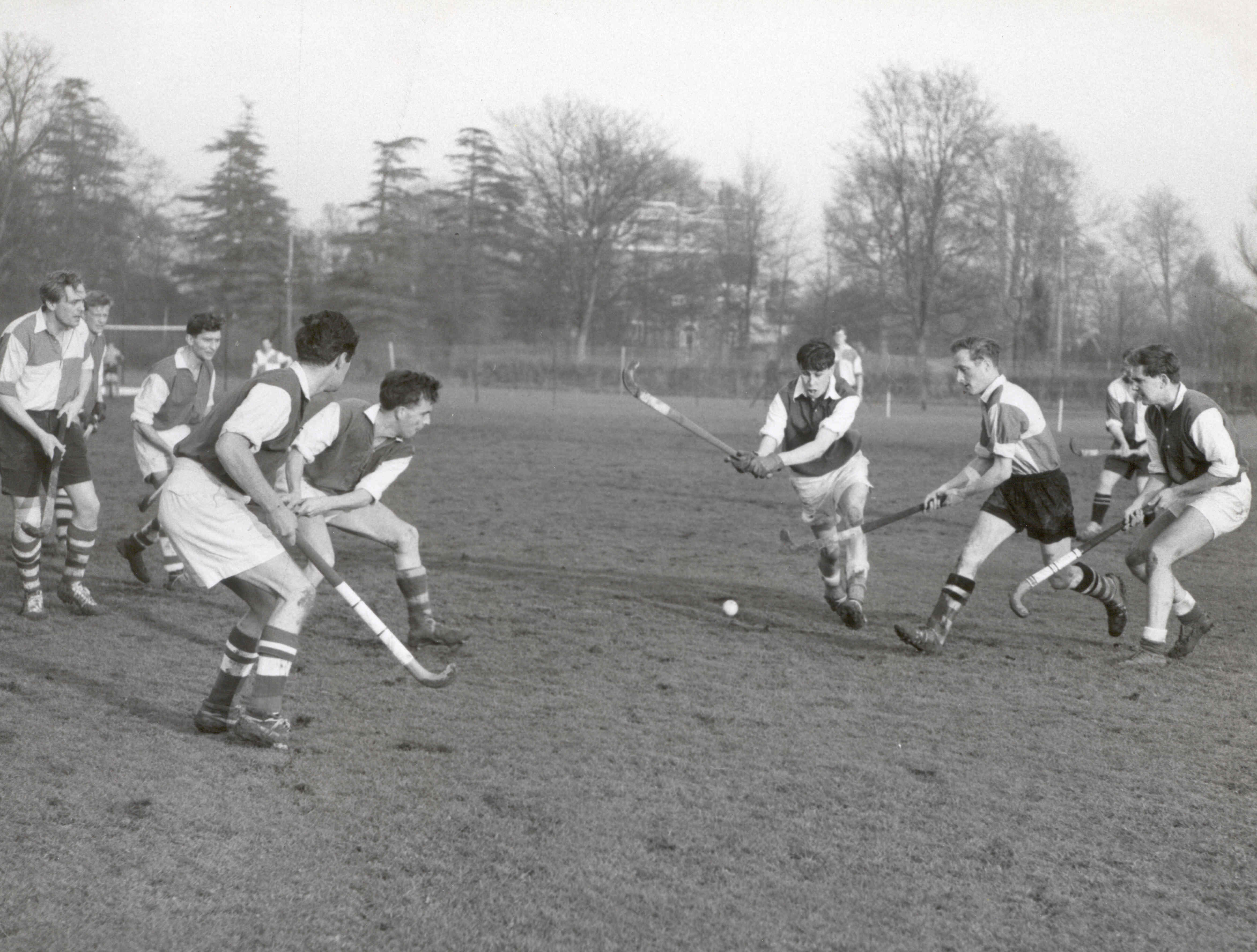 A.E.R.E. Hockey Club in action. Bob Hopgood (centre) tackles the opposing inside left while John Penney and Angwin Marples await developments.  Also watching anxiously were John Doran (formerly with Contracts) and John Austin - 2nd and 3rd from the left - and John Forbes (SRC) - extreme right.