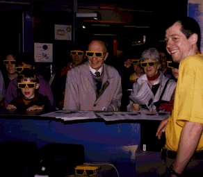 Figure 1: Chris Seelig gives visitors of all ages a view of some virtual worlds at AISG's VR booth during the public day