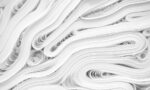 Photograph of rolled-up sheets of white paper, arranged in layers