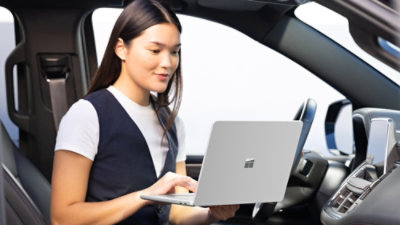 Une personne dans une voiture utilisant un ordinateur portable.