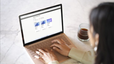 صورة لشخص يكتب على جهاز كمبيوتر محمول يعرض Microsoft 365.