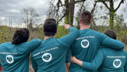 OnPoint employees with their arms around each other while volunteering
