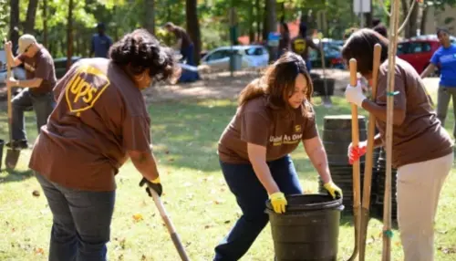 Volunteers from UPS Foundation work together to clean up a green space