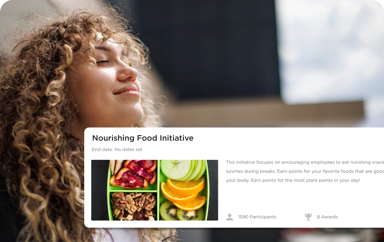 Curly-haired woman with eyes closed smiling, alongside a Nourishing Food Initiative info card featuring a photo of healthy snacks like walnuts, blood oranges, green apple slices, orange slices, and kiwi.