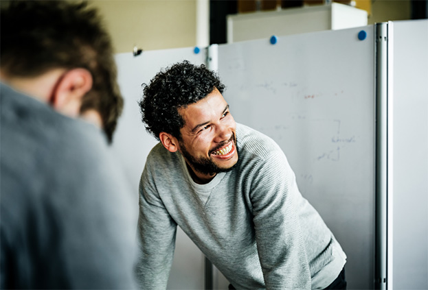 An employee laughing in front of a white board