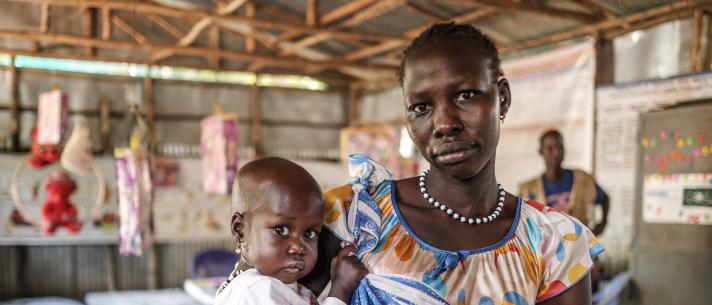 Woman holding a child in her arms.