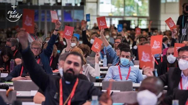 Karlsruhe, Germany: Assembly participants raise consensus cards into the air -- some orange in affirmation, some blue in disagreement with what is being said -- during a closing business plenary at the 11th Assembly of the World Council of Churches, held in Karlsruhe, Germany from 31 August to 8 September, under the theme 'Christ's Love Moves the World to Reconciliation and Unity'