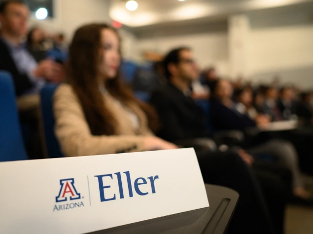 Eller table tent rests on desk in foreground with students listening to lecture in background