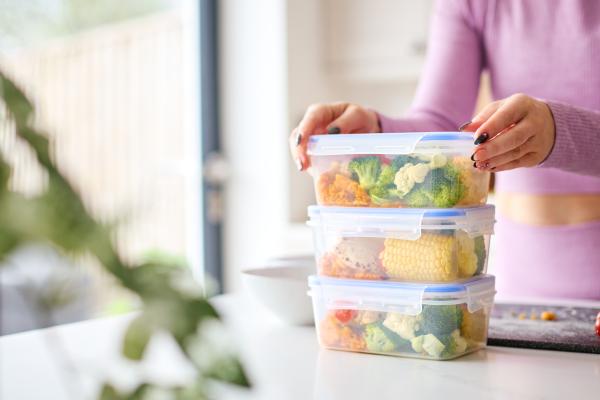Close Up Of Woman Wearing Fitness Clothing At Home In Kitchen Making Healthy Meals For The Freezer