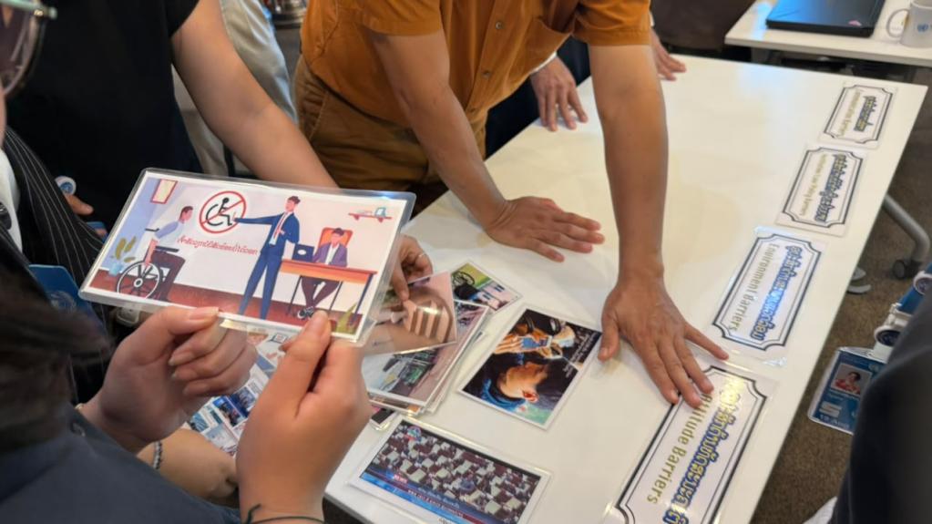 Colleagues looking at the image cards and identify the barriers to accessibility.