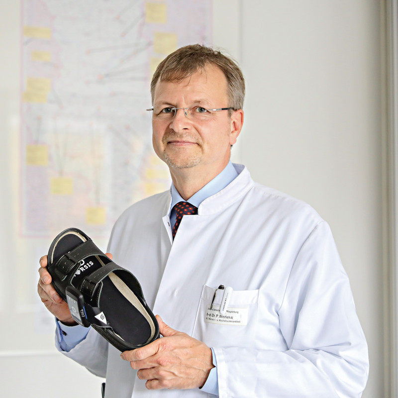 Das Bild zeigt Prof. Dr. Peter R. Mertens mit der intelligenten Einlegesohle in der Hand.