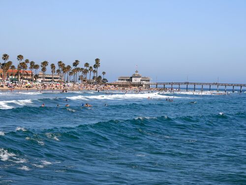 "Newport Beach,CA in summer with crowds swimming and sunning near pier"