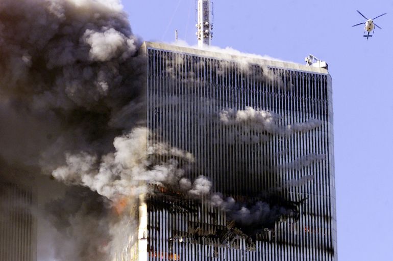 The World Trade Center in New York City burns as a police helicopter flies nearby early September 11, 2001. Both towers were hit by planes crashing into the building. Shortly after this photo was taken both towers fell.