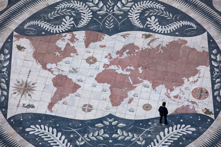 A man looks at a map of the world.
