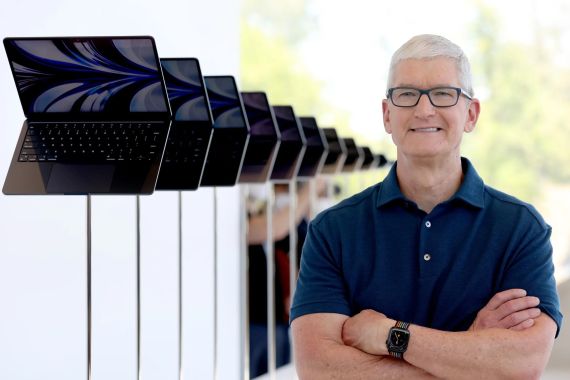 CUPERTINO, CALIFORNIA - JUNE 06: Apple CEO Tim Cook looks at a display of brand new redesigned MacBook Air laptop during the WWDC22 at Apple Park on June 06, 2022 in Cupertino, California. Apple CEO Tim Cook kicked off the annual WWDC22 developer conference. (Photo by Justin Sullivan/Getty Images)