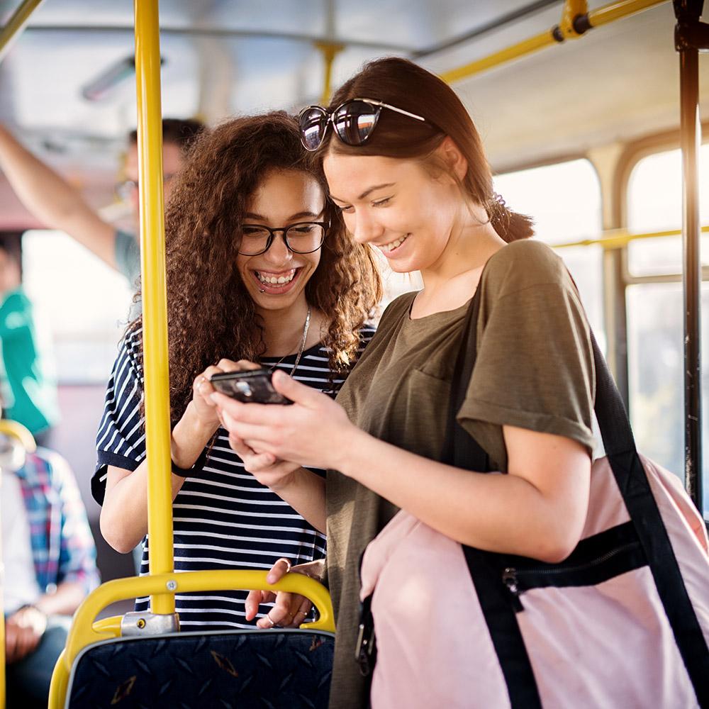 Women looking at smartphone in a bus