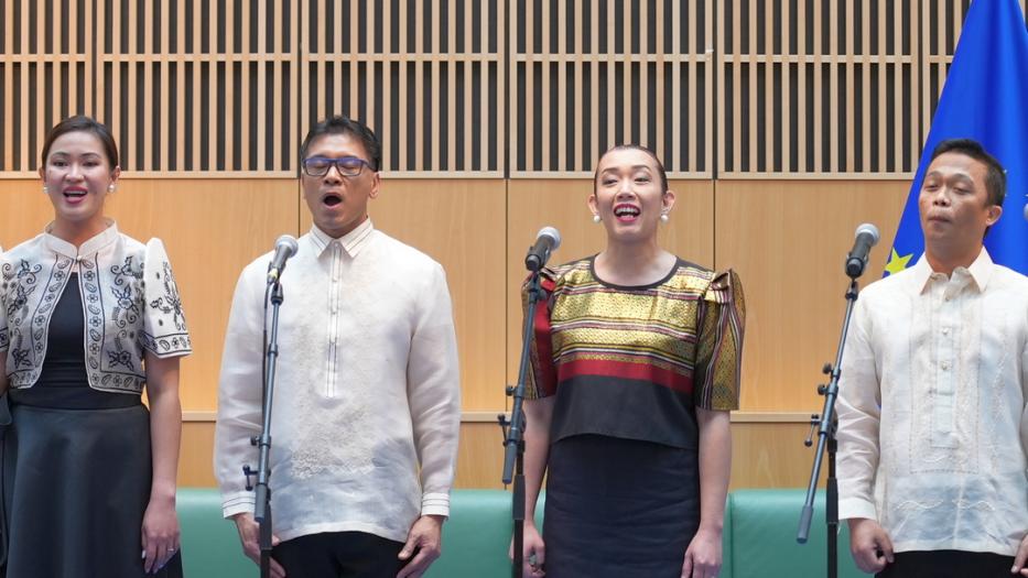 Four singers on stage performing.