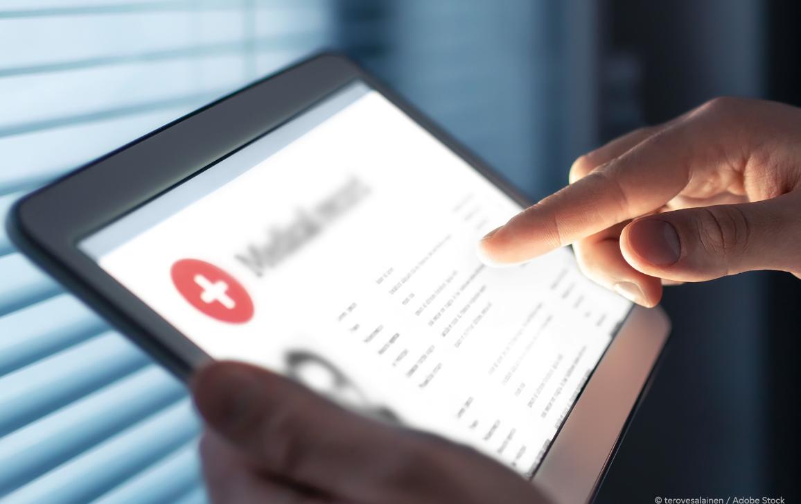 Hand pointing at the medical record and health data of a patient on a tablet