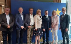7 MEPs standing in front of a blue wall