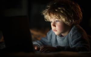 a child looking at a screen in the dark