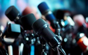 Photo showing a close-up of about ten microphones and relating to the media