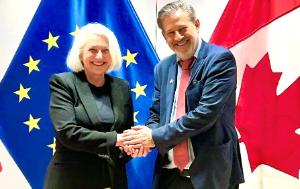 Javier Moreno Sánchez, Chair of the Delegation for relations with Canada and Joanne Thompson, Minister of Fisheries and Oceans (Canada) shaking hands and posing for a photo in front of the EU and Canadian flags.