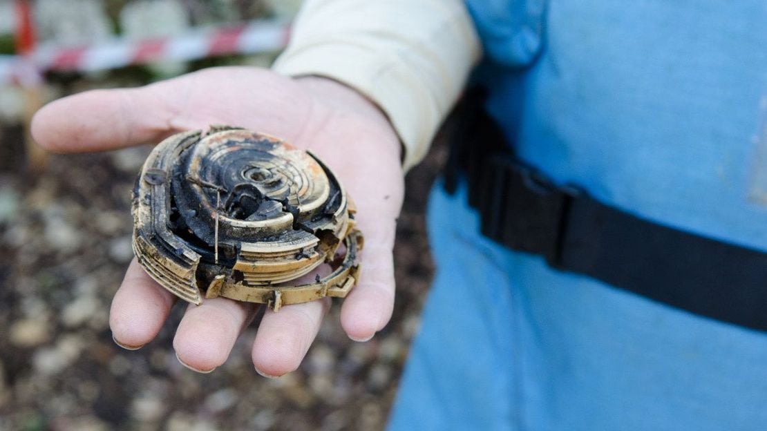 Nahaufnahme eines entschärften Blindgängers. Eine Entminerin präsentiert ihn auf der offenen Handfläche.