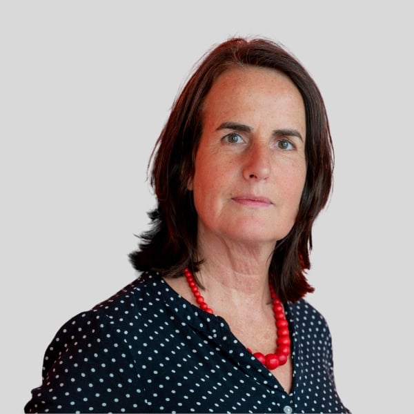 Eine Frau mit dunklen Haaren lächelt sanft.