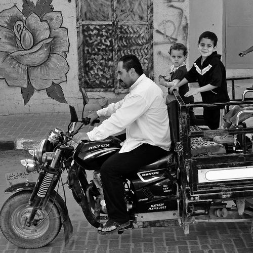 Fotoausstellung in einem Gebäude der Humboldt Universität Berlin. Die Ausstellung ist aus der Ferne zu sehen. Ein Interessierter betrachtet sie, drum herum emsiges Uni-Treiben.