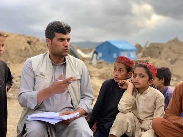 Ein Mann erklärt Kindern, wie sie Blindgänger erkennen können.