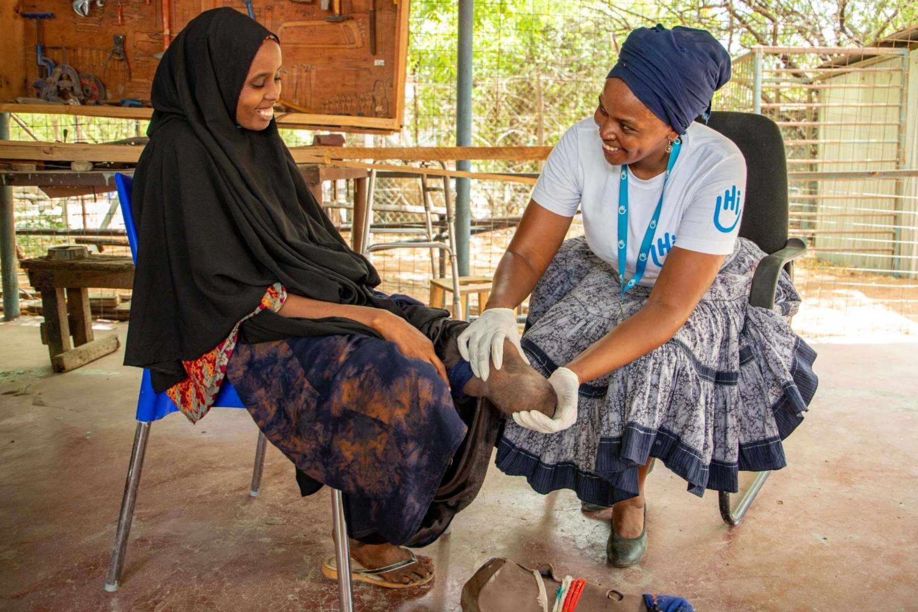 Während einer Physiotherapie-Session in Kenya. Eine Mitarbeiterin von HI versorgt eine Patentin mit Amputation.