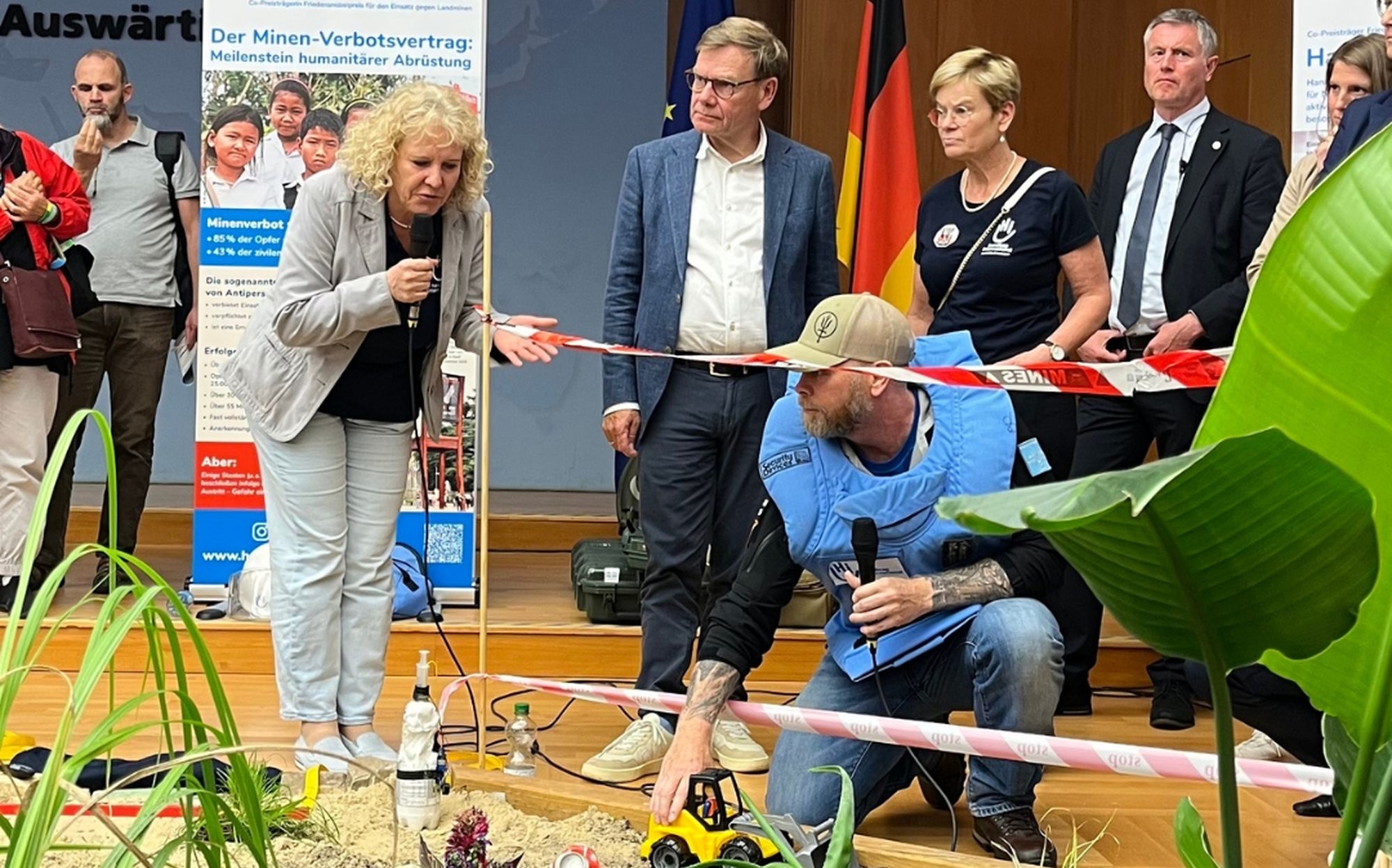 Aussenminister Wadephul mit Mitarbeitenden von Handicap International an einem künstlichen Minenfeld