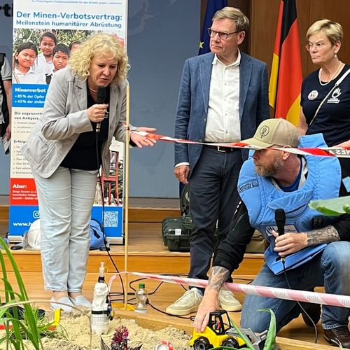 Aussenminister Wadephul mit Mitarbeitenden von Handicap International an einem künstlichen Minenfeld