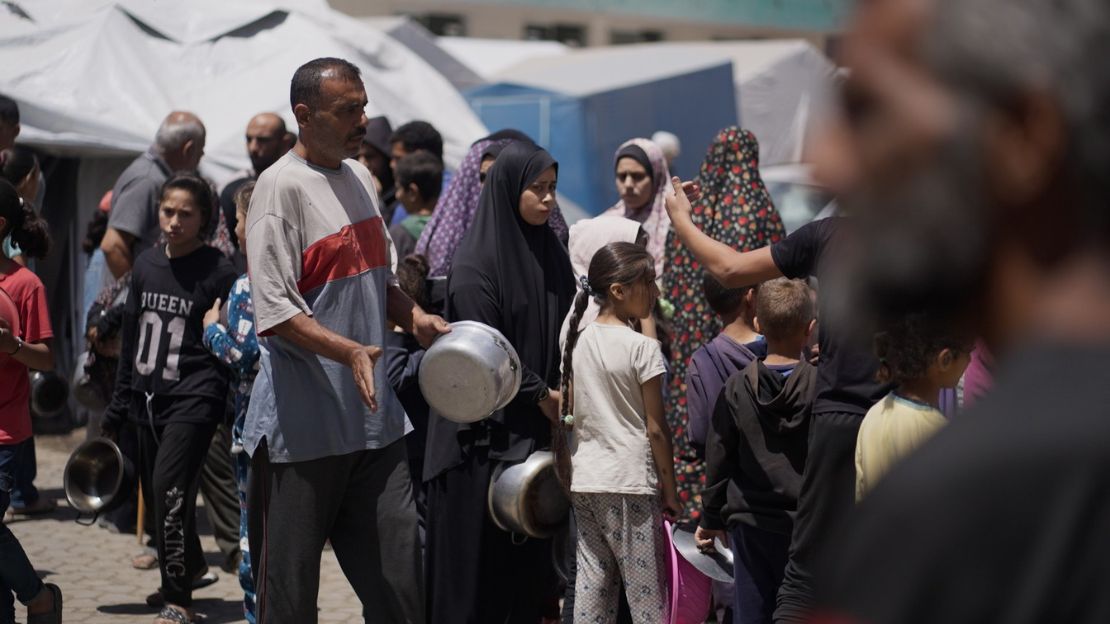Men, women and children line up for a food distribution in Gaza.