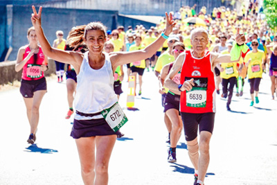 Two runners smile at the camera.