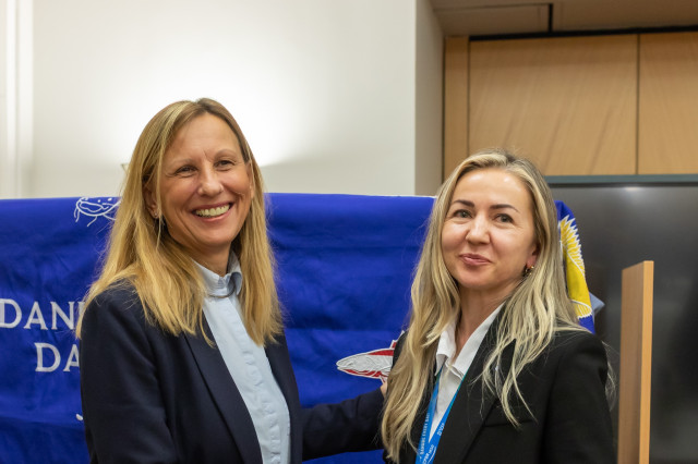 two women shaking hands and smiling