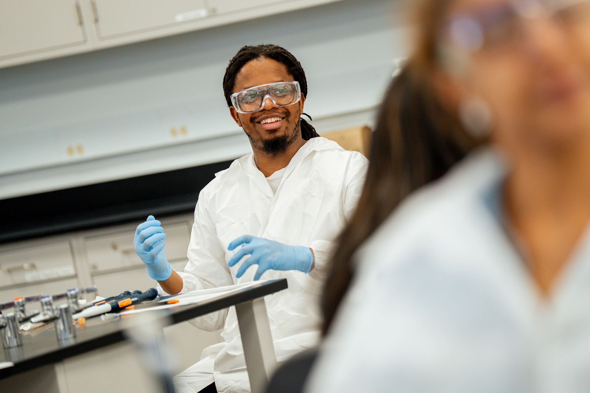 Karl Hill, wearing a lab coat and safety glasses, during BioSTL's Biotech Boot Camp.