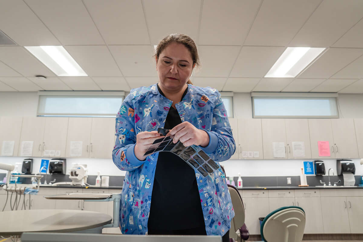 Yuliia in the dentist's room, checking x-rays.