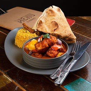 A plate of curry, rice and naan bread.