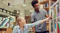Assistance reaching a book from a library shelf.