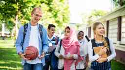 Young teenagers walking in a group outside on a sunny day.