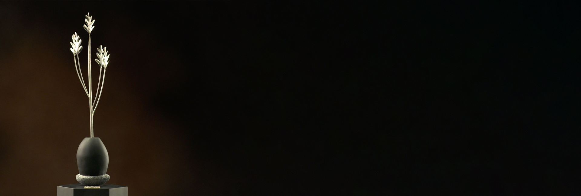 Alumni Achievement award trophy on a dark background