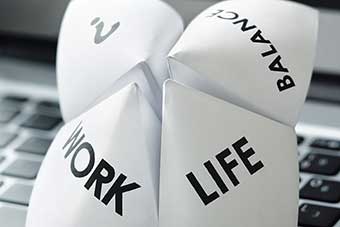 Origami fortune teller on laptop in office concept for work life balance choices