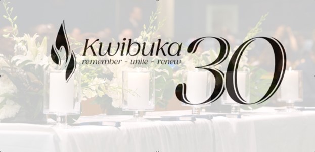 Kwibuka30 sign with candles and flowers on table