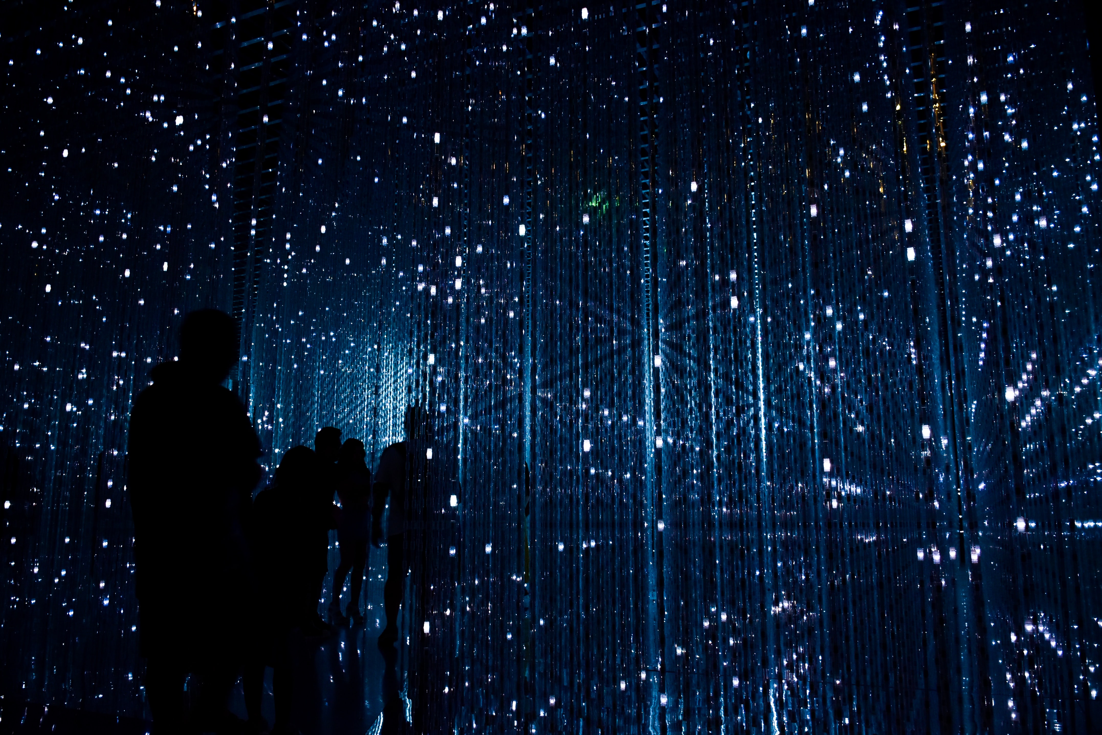 Gente caminando entre rayos de luz.