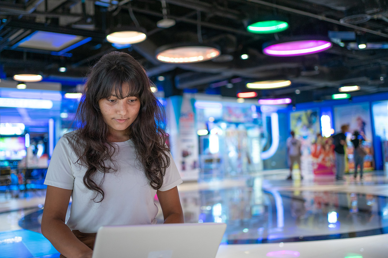 A girl using a laptop in a museum 