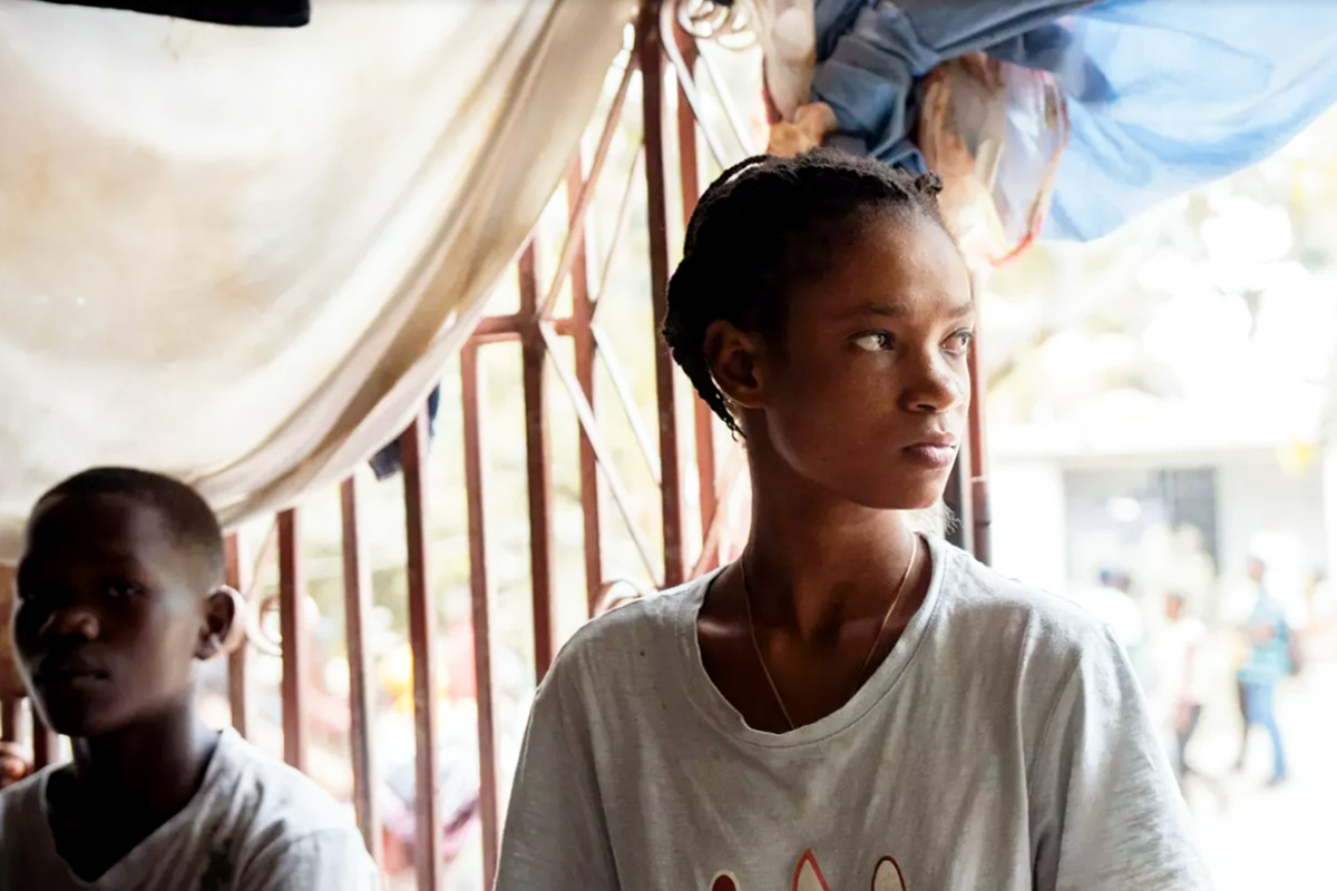 Pictured are a young girl looking to her left while a young boy sitting behind her is looking ahead. Both have troubled expressions on their faces.