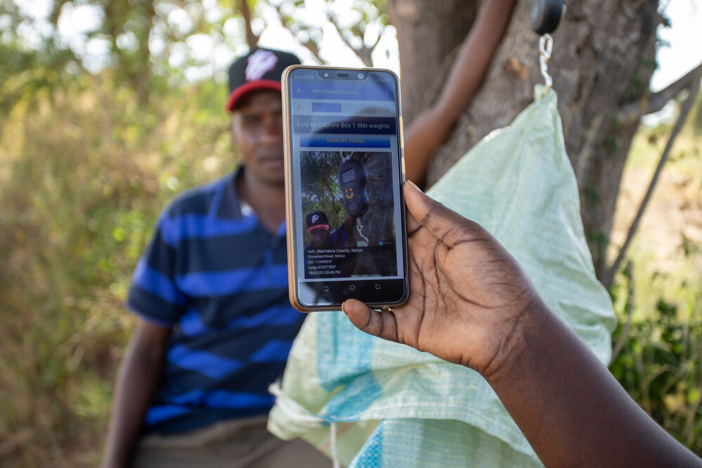A woman taking a picture of a trader.