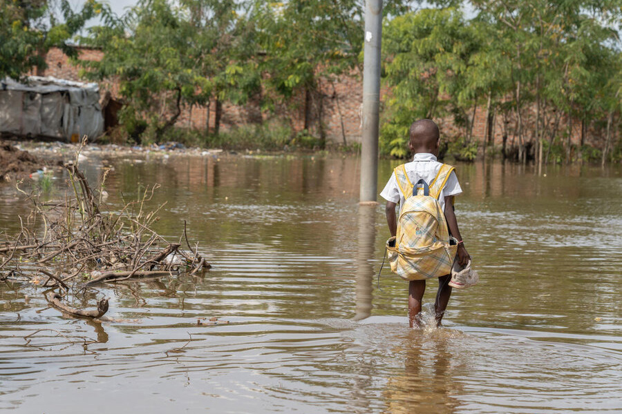 a child in school uniform wading through water